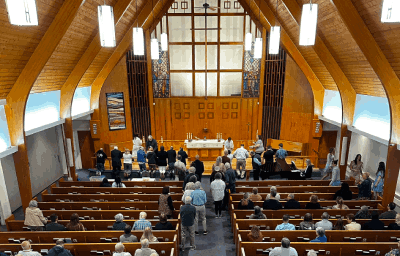 Congregation going forward to the altar rail to stand or kneel for communion.
