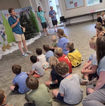 Pastor Chris speaking in front of children at Vacation Bible School